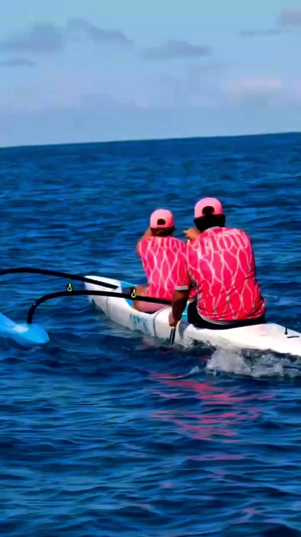 Two paddlers in an OC2 head out to sea