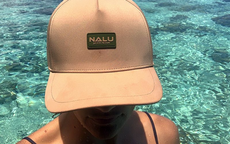 A Nalu hat worn over clear reef water