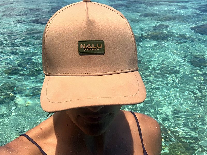 A Nalu hat worn over clear reef water